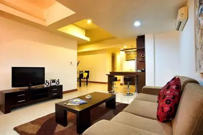 a living room with a couch and a flat screen tv at Sunset Residence and Condotel in Legian