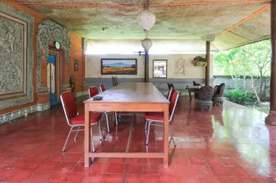 a dining room with a wooden table and chairs at Mertha Jati Hotel in Kuta