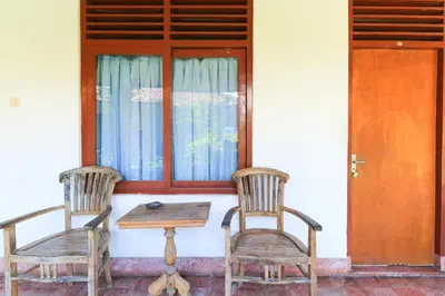 two chairs and a table in front of a door at Mertha Jati Hotel in Kuta