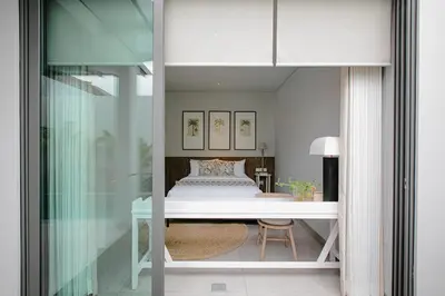 a bedroom with a bed and a desk in a room at Casamaya Villa in Legian