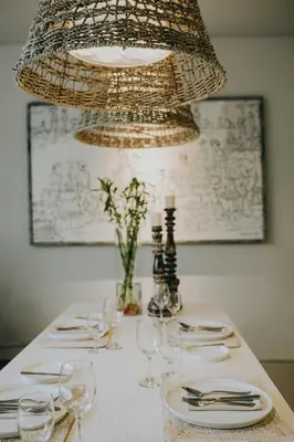a table with wine glasses and a chandelier at Casamaya Villa in Legian