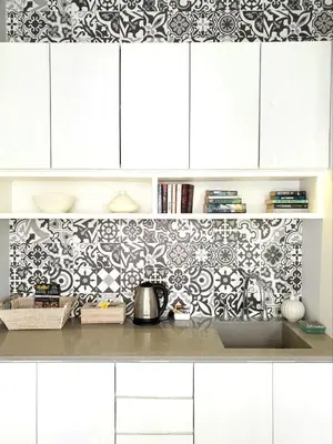 a kitchen with white cabinets and a black and white wallpaper at Casamaya Villa in Legian