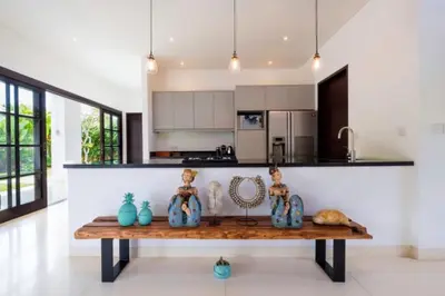 a kitchen with a table with vases on it at Villa Eva in Seminyak