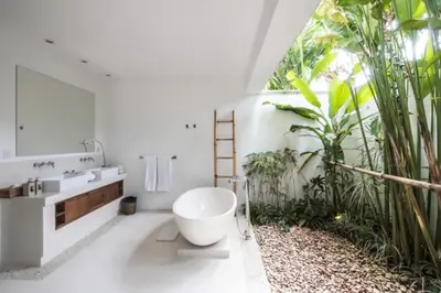 a bathroom with a large window and a large white tub at Villa Eva in Seminyak