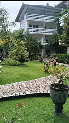 a garden with a stone path in front of a building at Grand Kumala Hotel - Hotel Kumala Legian Kuta Bali in Legian