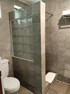 a bathroom with a toilet and a walk in shower at Grand Kumala Hotel - Hotel Kumala Legian Kuta Bali in Legian