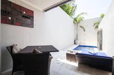 a patio with a table and a swimming pool at Kuta Regency B10 One Bedroom Villa in Kuta