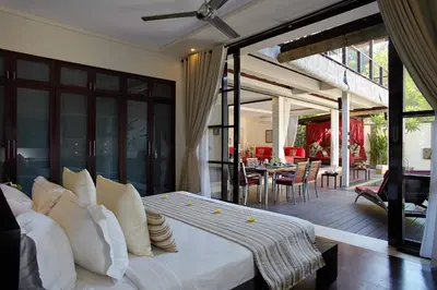 a bedroom with a large white bed and a patio at Temple Hill Residence Villa in Jimbaran