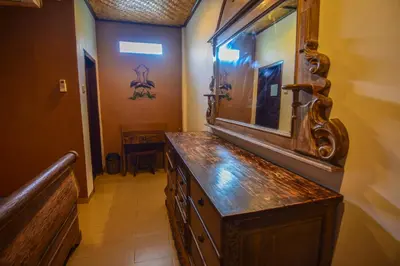 a bathroom with a wooden dresser and a mirror at Puri Agung Homestay in Kuta