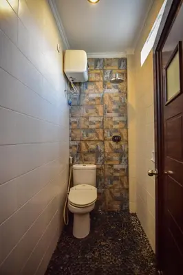 a bathroom with a toilet in a room at Puri Agung Homestay in Kuta