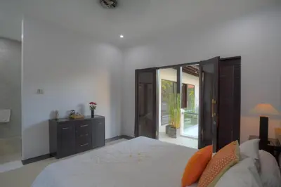 a bedroom with a large bed and a couch at Kedis Bali Villa in Kuta