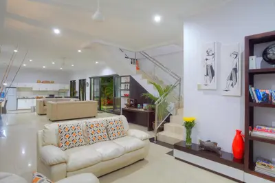 a living room with a couch and a staircase at Kedis Bali Villa in Kuta