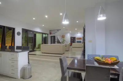 a kitchen and dining room with a bowl of fruit on a table at Kedis Bali Villa in Kuta