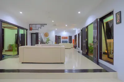 a lobby with two white couches in a building at Kedis Bali Villa in Kuta