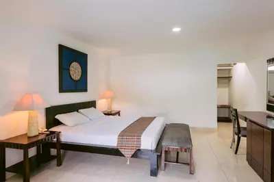 a bedroom with a bed and a desk and a kitchen at Legong Keraton Beach Hotel in Canggu