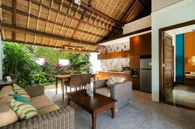 an open living room with a table and a kitchen at Kecapi Villa Seminyak by Ini Vie Hospitality in Seminyak