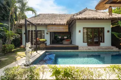 a villa with a swimming pool in front of a house at Kecapi Villa Seminyak by Ini Vie Hospitality in Seminyak