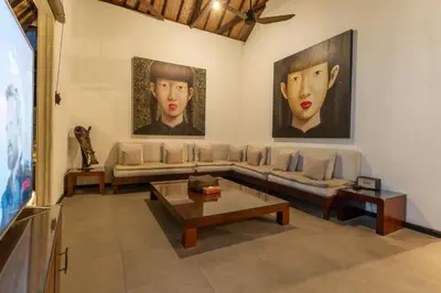 a living room with a couch and two paintings on the wall at Villa Dewata 3 in Seminyak