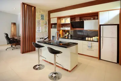 a kitchen with two bar stools and a counter at Villa Mawar Legian in Legian
