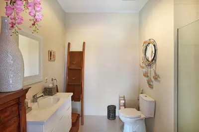a bathroom with a toilet and a sink and a mirror at Villa Mawar Legian in Legian