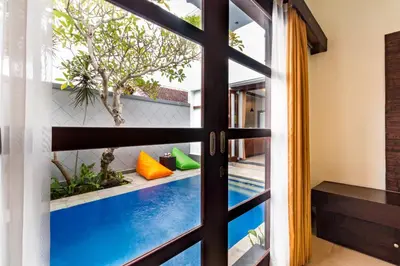 a door leading to a swimming pool seen from a house at Villa Chandraika - 3BR Private Pool Villa by AGATA in Seminyak