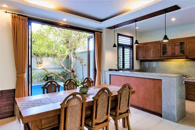 a kitchen with a table and chairs and a large window at Villa Chandraika - 3BR Private Pool Villa by AGATA in Seminyak