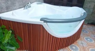 a bath tub with a sink on top of it at Villa Cantik Tresna in Seminyak