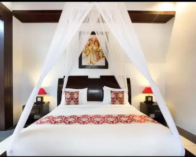 a bedroom with a bed with a mosquito net at Villa Cantik Tresna in Seminyak