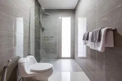 a bathroom with a toilet and a walk in shower at Surya Mas Villa in Legian