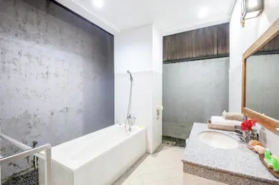 a bathroom with a white tub and a sink at Surya Mas Villa in Legian