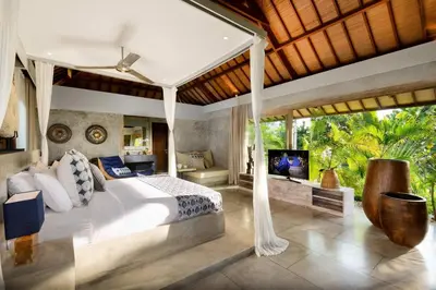 a bedroom with a large bed and a television at Lavish 5 Bed, Sleeps 10, Butler, Daily Breakfast in Canggu