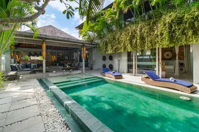 a swimming pool with chairs and a house at Lavish 5 Bed, Sleeps 10, Butler, Daily Breakfast in Canggu