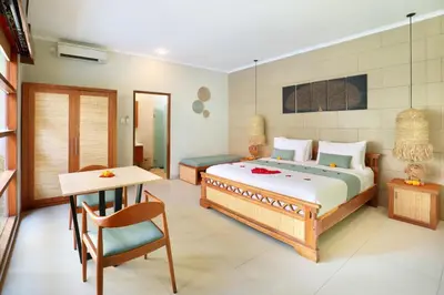 a bedroom with a bed and a table and a desk at The Vie Villa Legian in Legian