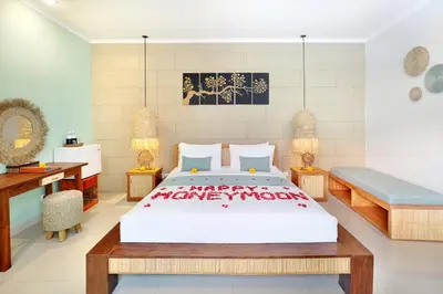 a bedroom with a large bed and a desk at The Vie Villa Legian in Legian