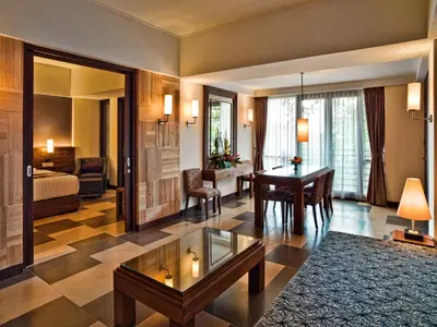 a living room with a table and a bedroom at Sun Island Hotel & Spa Kuta in Kuta