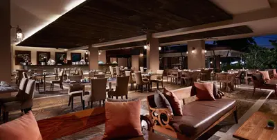 a restaurant with tables and chairs and a bar at Sun Island Hotel & Spa Kuta in Kuta