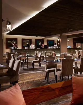 a restaurant with tables and chairs and a bar at Sun Island Hotel & Spa Kuta in Kuta