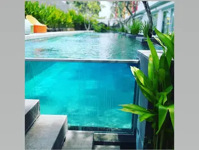 a swimming pool in a house with blue water at Zuri Express Jimbaran in Jimbaran