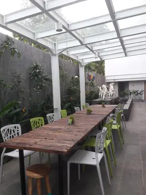 a wooden table and chairs under a pergola at Zuri Express Jimbaran in Jimbaran