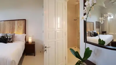 a bedroom with two beds and a mirror at Villa Pulau Rumah in Seminyak