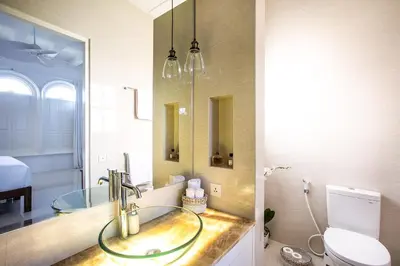 a bathroom with a sink and a toilet and a mirror at Villa Pulau Rumah in Seminyak