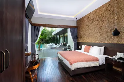 a hotel room with a bed and a patio at Del Cielo Villa Jimbaran in Jimbaran