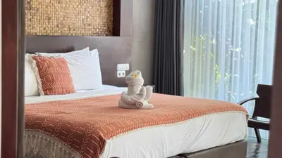 a stuffed animal sitting on a bed in a bedroom at Del Cielo Villa Jimbaran in Jimbaran