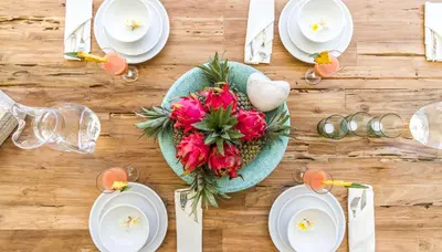 a table with white plates and a bouquet of flowers at Villa Smilla in Seminyak