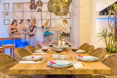 a wooden table with plates and glasses of wine at Villa Smilla in Seminyak