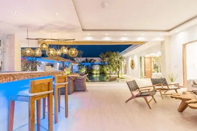 a kitchen with a bar and a living room at Villa Smilla in Seminyak