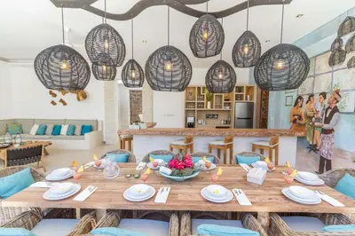 a dining room with a table and chairs and lights at Villa Smilla in Seminyak