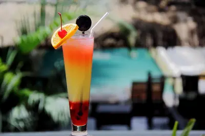 a drink with an orange slice and a fruit at Serela Kuta in Kuta