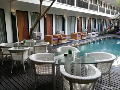 a patio with tables and chairs next to a swimming pool at Serela Kuta in Kuta