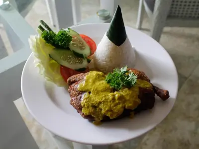 a plate of food with meat and vegetables on a table at Serela Kuta in Kuta